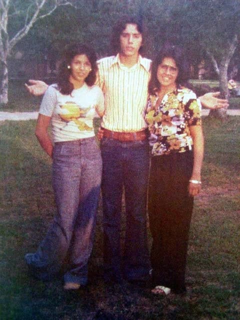 Three friends on the lawn in their best 1970s outfits.