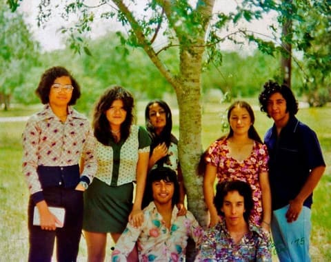 Eight students posing under a tree on the campus lawn; commenters recognize Marcos Entenza among them.
