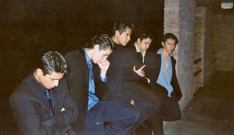 “The Crazys”: five friends in suits striking poses by the dorm at night.