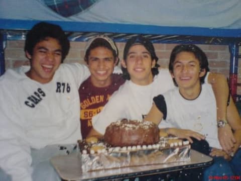 Four friends with a birthday cake in the dorm.