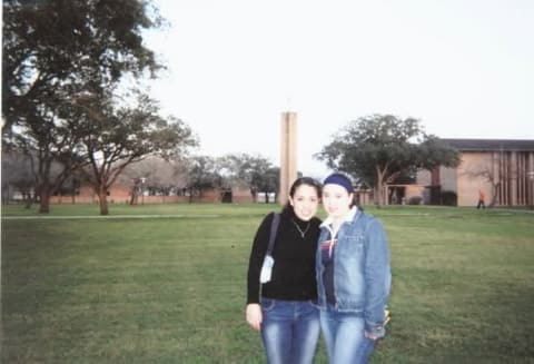Sisters Clelia and Iscely Moreno on the lawn in front of the chapel tower.