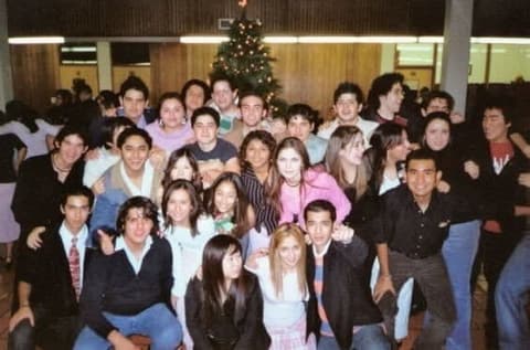 A big group of students by the Christmas tree in the dining hall, mid-2000s.