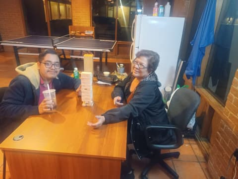A dorm parent playing Jenga with one of “her boys” in the dorm lounge.