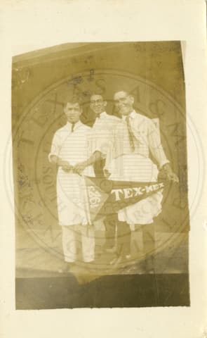 At Tex-Mex: Three boys standing on a porch of a house they are holding a flag banner that says “Tex Mex 1923”