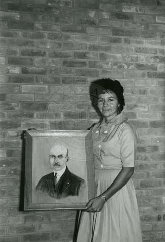 Teacher holding a portrait.