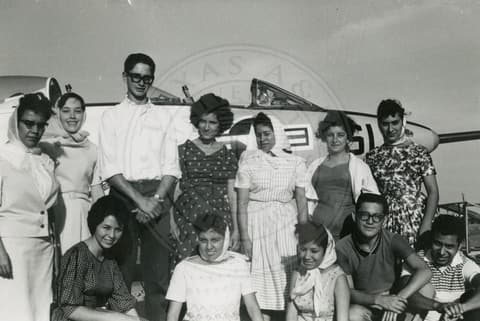 Students beside an aeroplane.