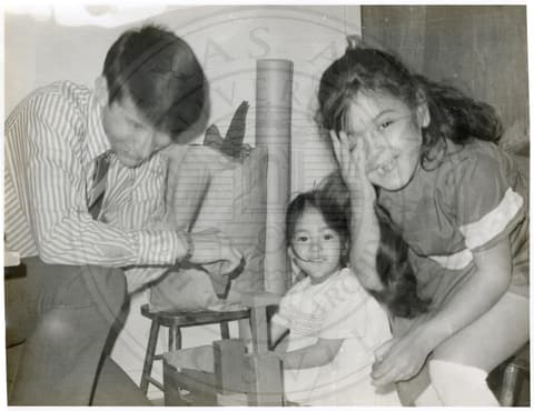 Faculty Member & Students. Two small girls and a man laughing.